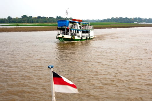 Boat traffic on the Amazon and flag of the state of Amazonia Brazil