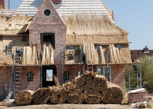A North German house with a thatched roof is built