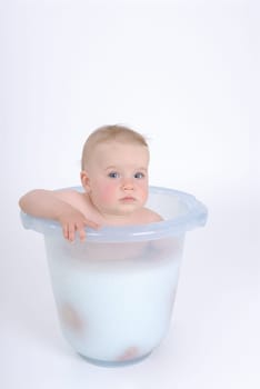One-year-old child takes a bath (with milk)