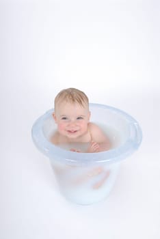 One-year-old child takes a bath (with milk)