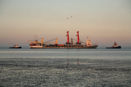 Special cargo ship "Wiebke"" with two large cranes,escorted by two tugboats"