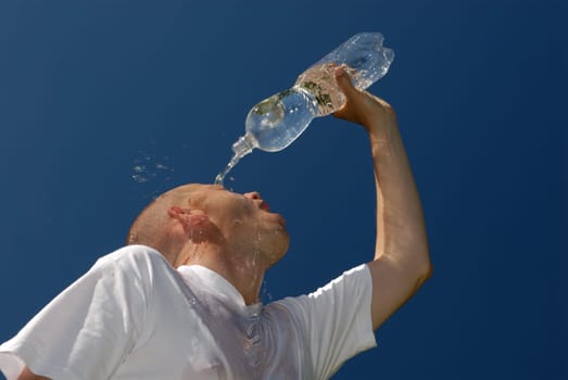 Young man pours water on his head