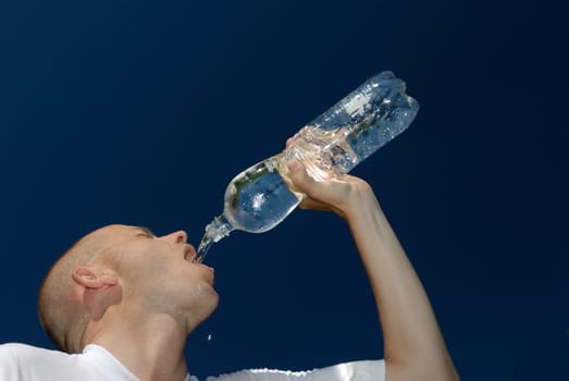 Young man drinking from a bottle of water