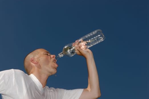 Young man drinking from a bottle of water