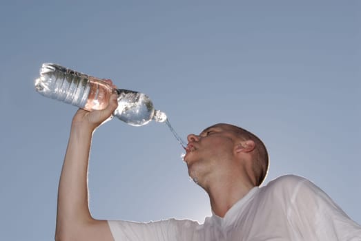 Juner man drinking from a bottle of water