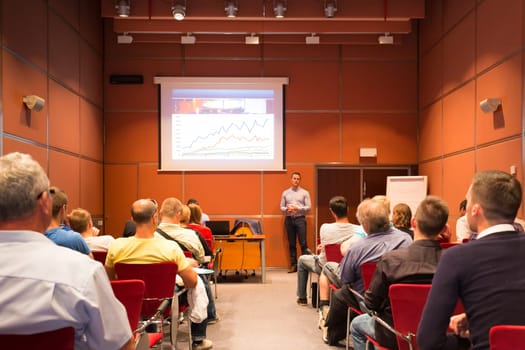 Speaker giving a talk in conference hall at business event. Unrecognizable people in audience at conference hall. Business and Entrepreneurship concept.