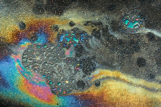 Colored oil stains close-up, color of a gasoline stain on asphalt as a texture or background.