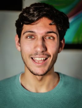 Surprised, happy handsome young man looking at camera, at home