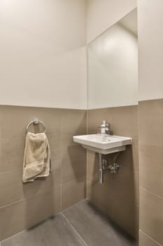 a bathroom with a towel hanging on the wall and a sink in the corner next to the toilet is white