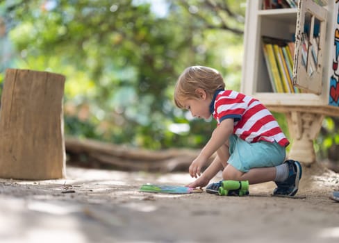 Cute little blonde boy playing on the playground. Mid shot