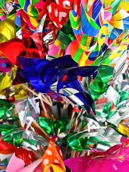 Numerous colorful toy windmills in a large display stand