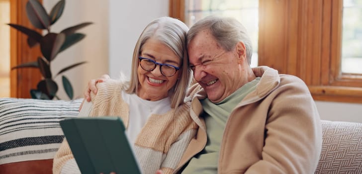 Tablet, laugh and senior couple on a sofa watching a funny, comic or comedy video on social media. Happy, smile and elderly people in retirement scroll on mobile app or internet on digital technology.