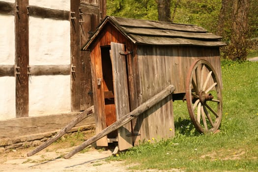 Historic shepherd's cart in front of an old farm