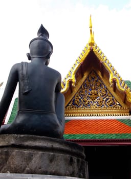Siddhartha Gautama looks to the entrance of Wat Phra Kaew Temple of the Emerald Buddha Bangkok Thailand