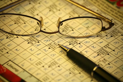 Crossword puzzle with glasses and pen