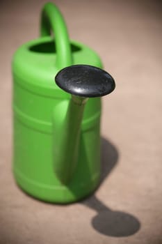 Green plastic watering can