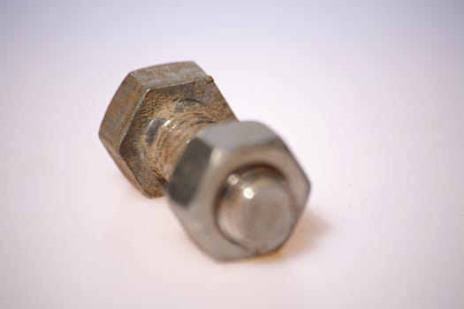 Short screw with nut against white background