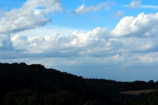 Landscape shot with beautiful cloud formation. Due to the incoming sun,the clouds stand out very clearly against the sky. The use of a polarizing filter created the strong blue color of the sky