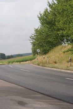 A section of a small winding country road with the traffic sign "Speed limit lifted!"""