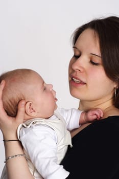 Mom holds her child in her arms and they look into each other's eyes