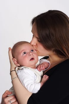 Mom kisses her child,which she holds in her arms