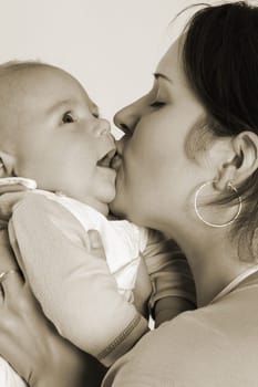 Mom kisses her child,which she holds in her arms