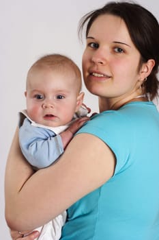 Mom smilingly holds her child in her arms