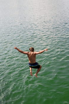 A young man jumps into the water