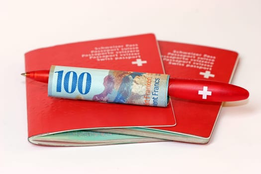 Two Swiss passports with 100 CHF with ballpoint pen