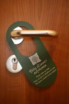Sign "Please clean up the room"" on a hotel room door"