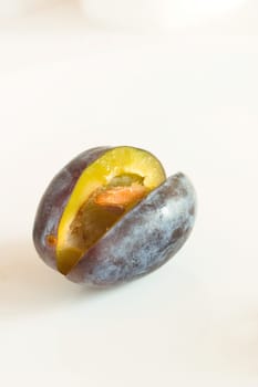 Plums,halved on a white background