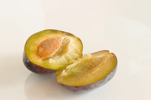 Plums,halved on a white background
