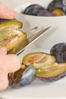 Plums,halved on a white background