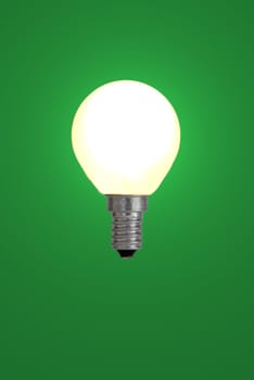 Light bulb against a green background