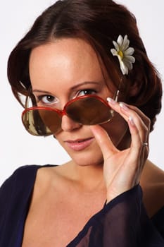 A woman looks boldly over her sunglasses