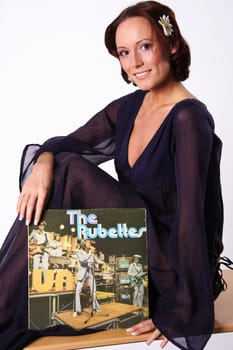 A smiling woman presents an LP
