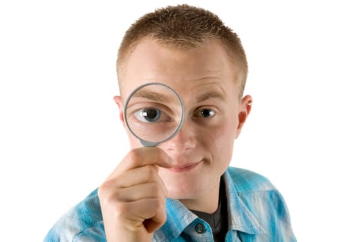 A young man looks through a magnifying glass