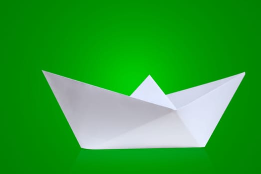 Paper boat against a green background