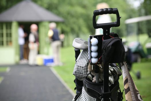 Golf trolley,golfers pausing in the background