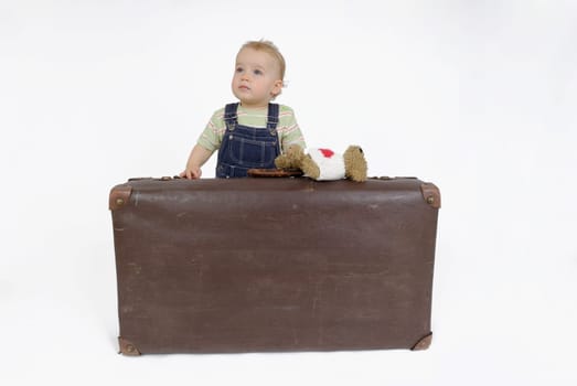 Toddler with suitcase and teddy bear. Studio recording