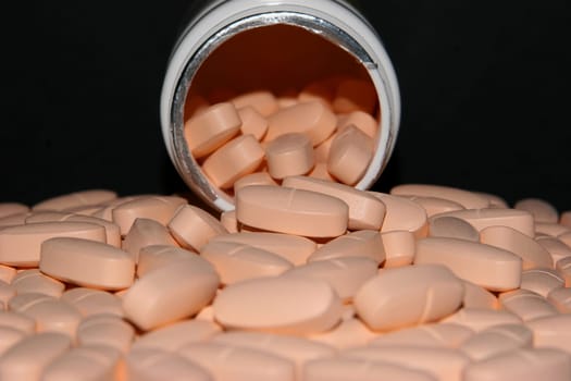 Can and tablets on black background