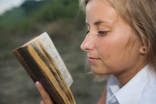 Close-up of a young woman reading a book.