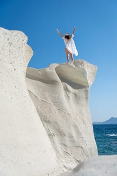 Model on top of a cliff in Sarakiniko, Milos Island