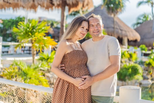 A happy, mature couple over 40, enjoying a leisurely walk in a park, their joy evident as they embrace the journey of pregnancy later in life.