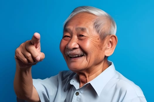 Asian grandfather looking and smiling with rised index finger on blue background. Neural network generated in May 2023. Not based on any actual person, scene or pattern.
