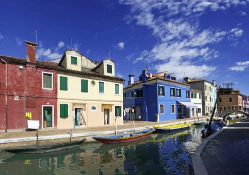 The island of Burano is located near Venice,and is known for its magnificently painted houses. The image is composed of five portrait images.
