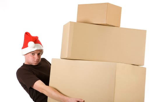 A man in a Santa Claus hat brings a stack of packages and looks strained