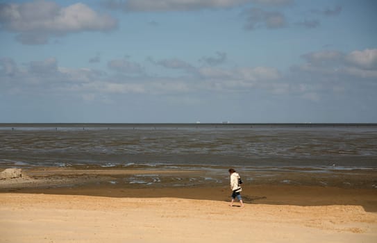 Lonely walker on the North Sea coast near Cuxhaven