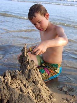 Child builds sand castle