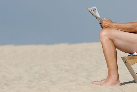 Newspaper reader on the beach